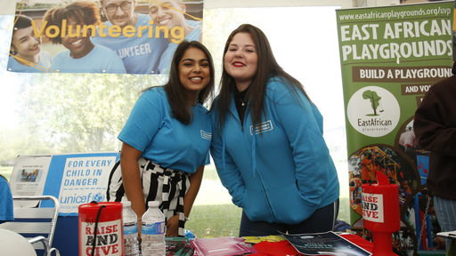 Two female students smiling on fair stand