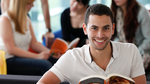Male student smiling with a book