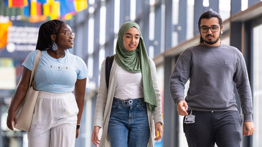 Image of three students walking through university