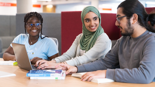 Three students working together at a laptop