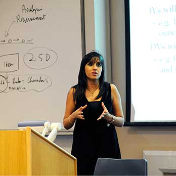 Women teaching in front of board