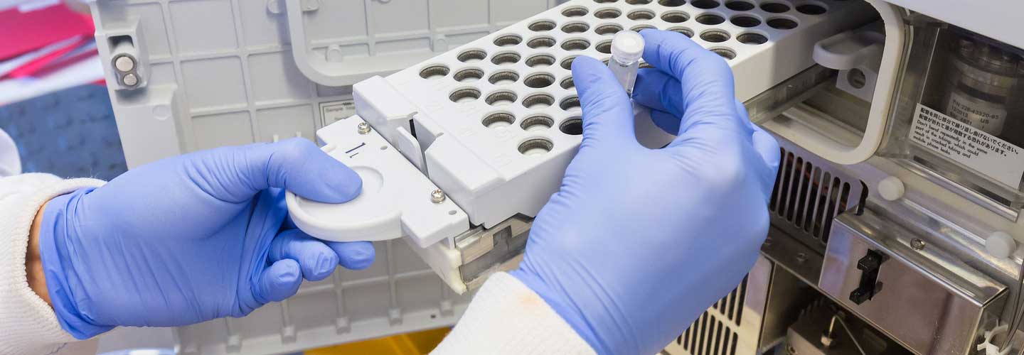 Gloved hands taking samples in lab