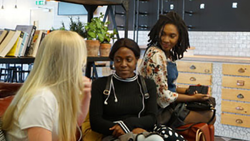 Three female students socialising on sofa