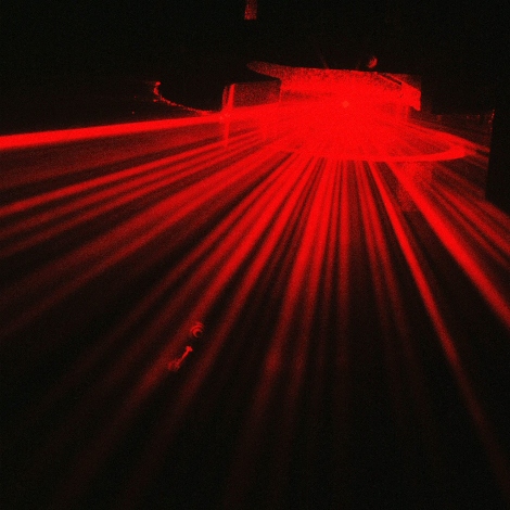 Red laser flare in dark room