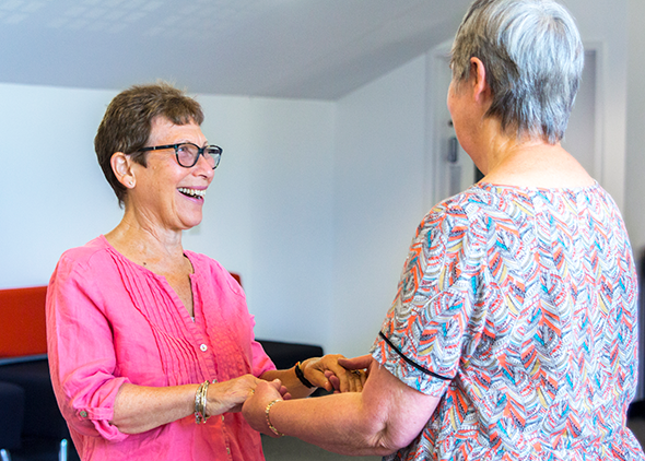 Two women smile as they dance