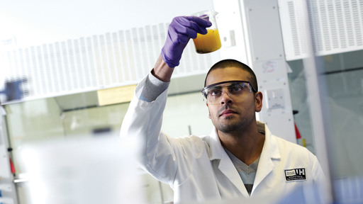 Male scientist looking at test tube