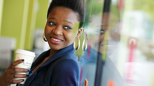 A female students smiles as she looks out of a window