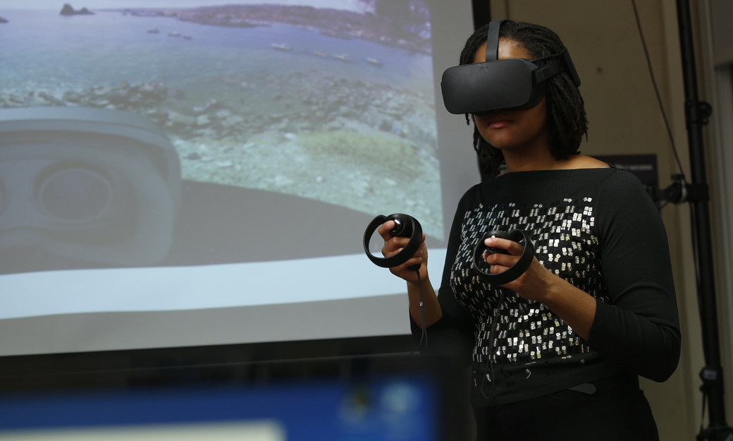 a female student using a virtual experience device in the virtual reality lab.