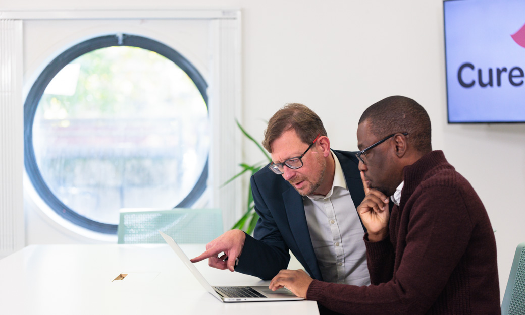 Man pointing whilst talking to another colleague