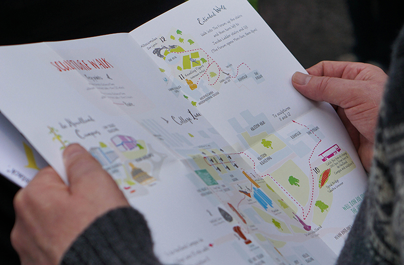 Person holding open Sculpture Walk map
