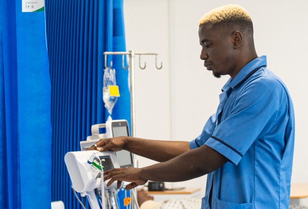 Nursing student reading results from a machine