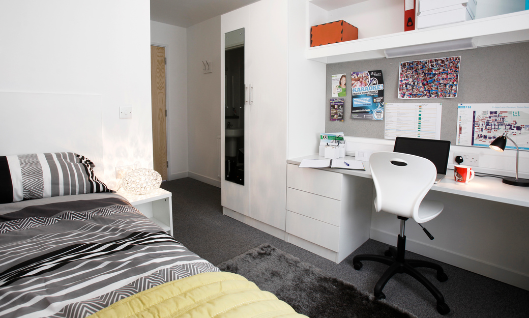 Ensuite room on campus showing bed, desk and wardrobe