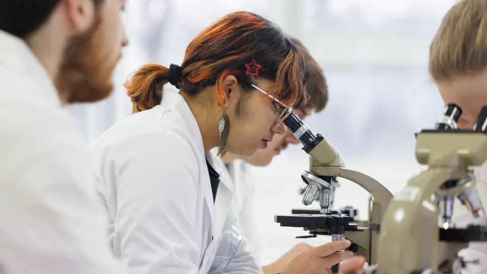 A student looking through a microscope 