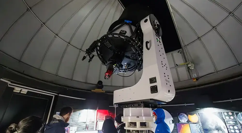 Students at the base of a large telescope