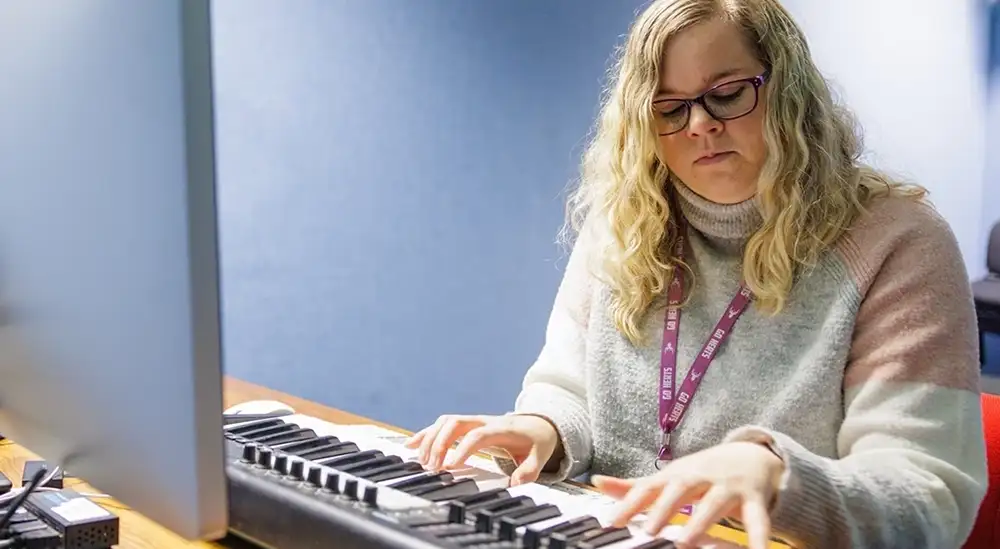 A student working playing a keyboard