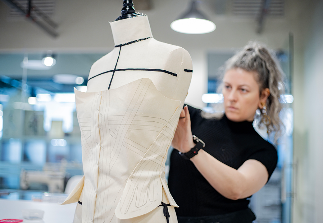 A person working on a sewing mannequin