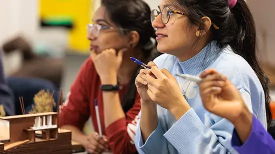 Students sitting in front of a design model