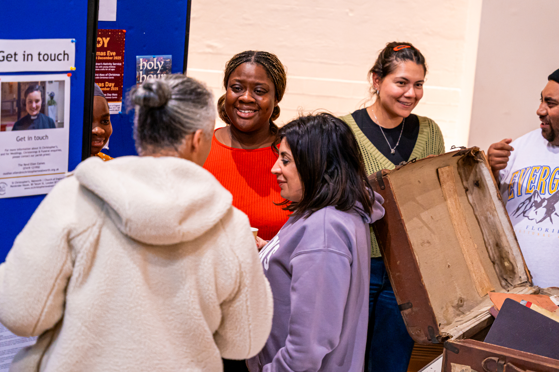 A diverse group of people look at an exhibition and discuss it
