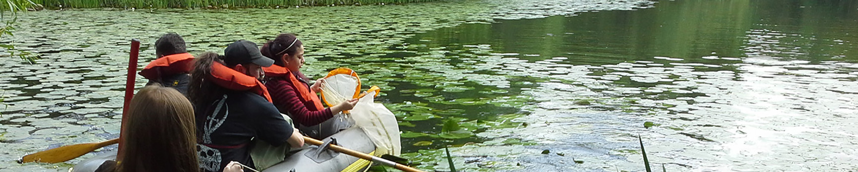 students lake sampling whilst in a boat