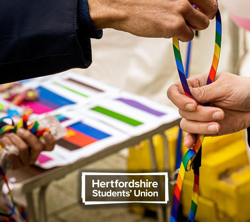 Person holding LGBT lanyard