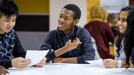 three diverse student sat at a desk 