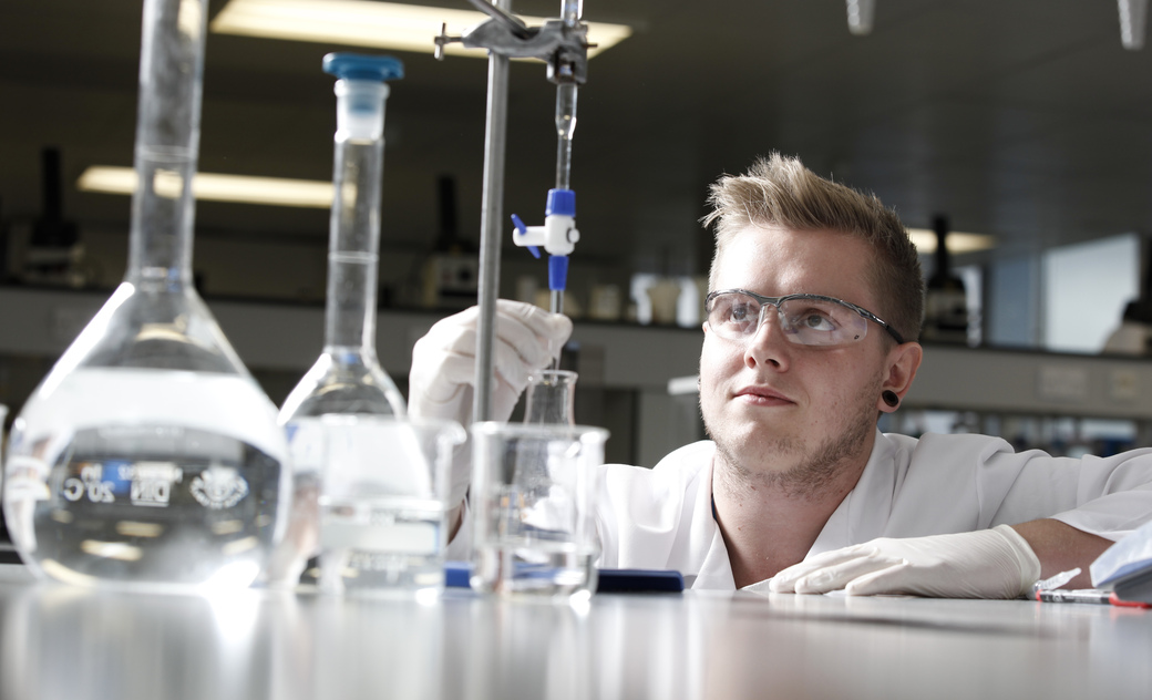 a male student watch a titration experiment very carefully 