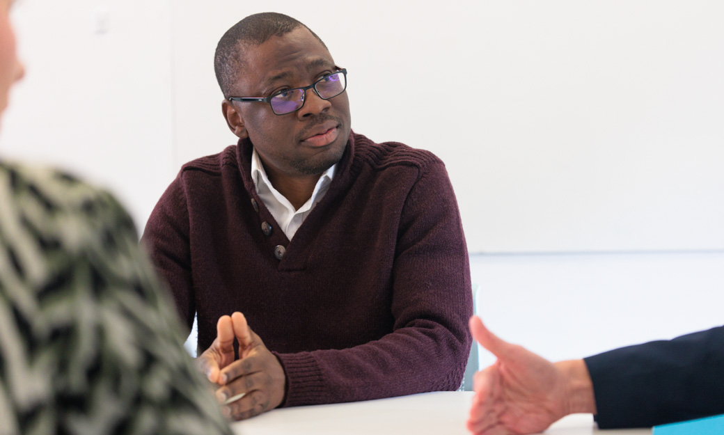 Sola founder of curenetics listening to colleagues