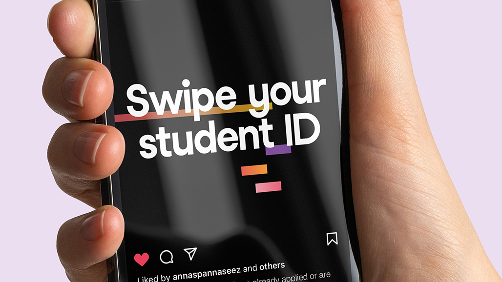 hand holding an iPhone, displaying a social media post by the university of hertfordshire