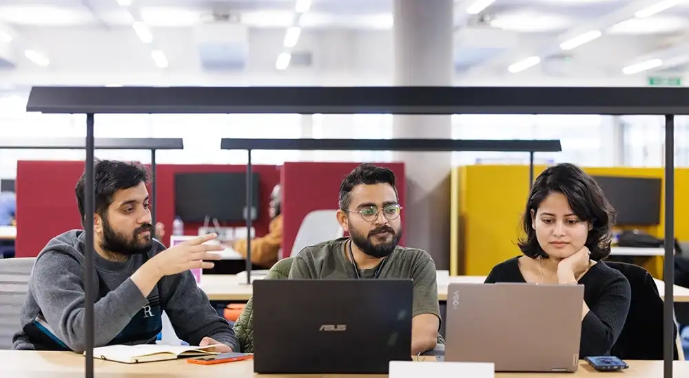 Three students talking and studying together