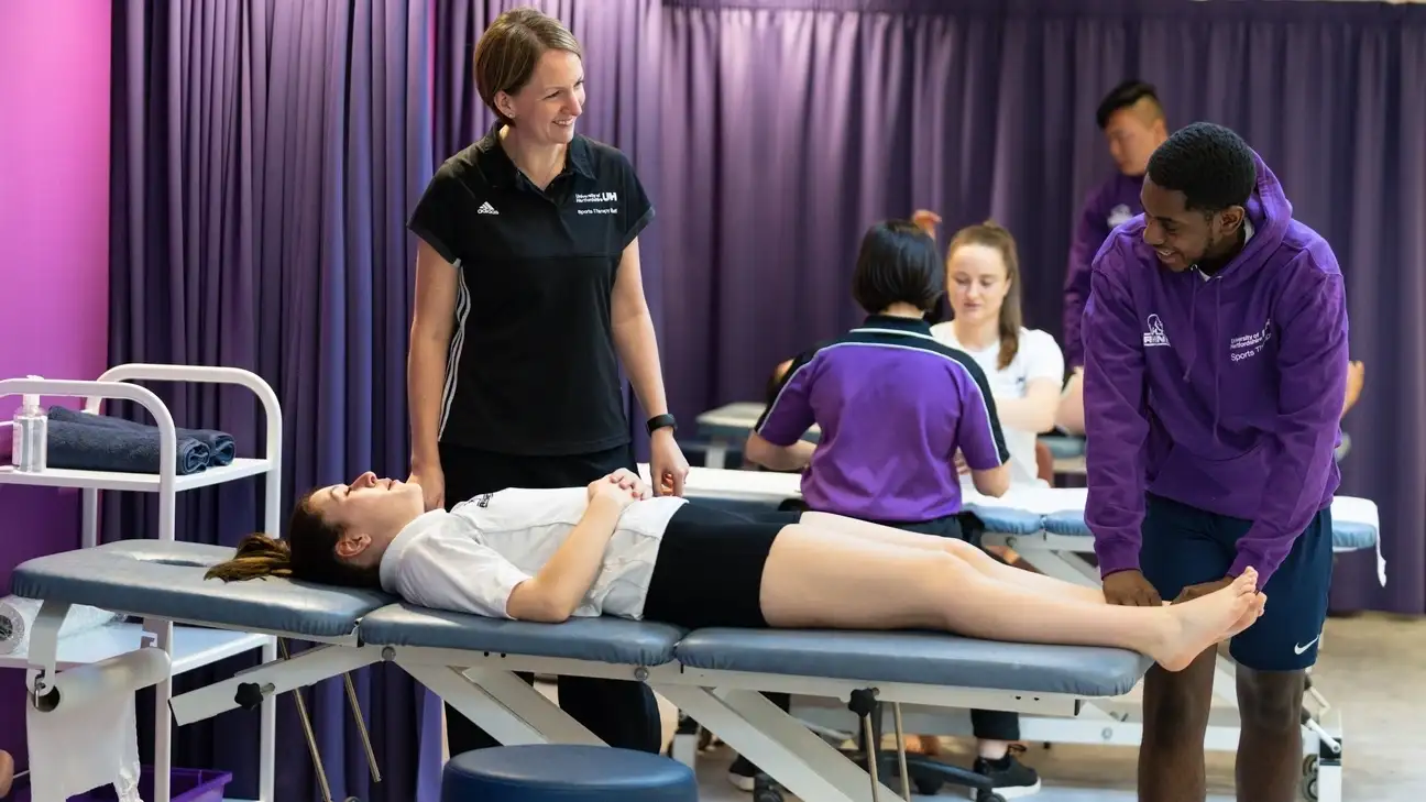 A student practicing on the ankle of another student