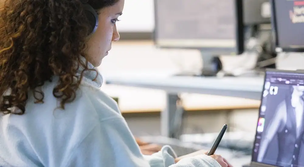 A student working on a laptop desiging