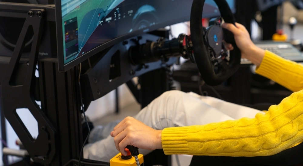 A student in a racing car simulation changing gear