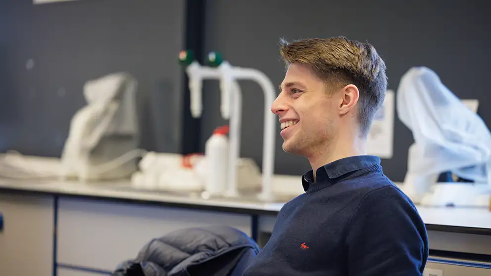 Student sitting in a chair leaning back smiling