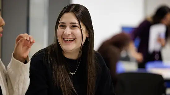 Student sitting down smiling and laughing