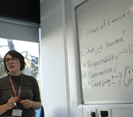 Female academic teaching next to whiteboard