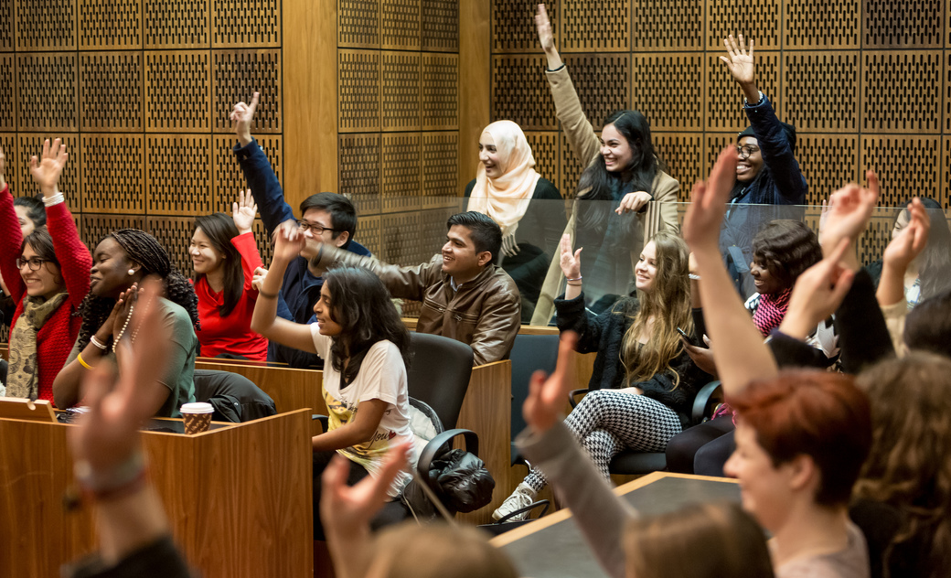 students raise their hand in mock court room