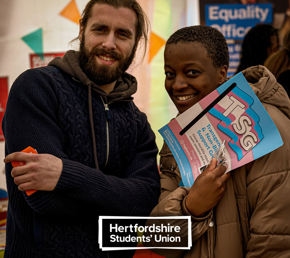 Female and male student holding leaflets on transgender