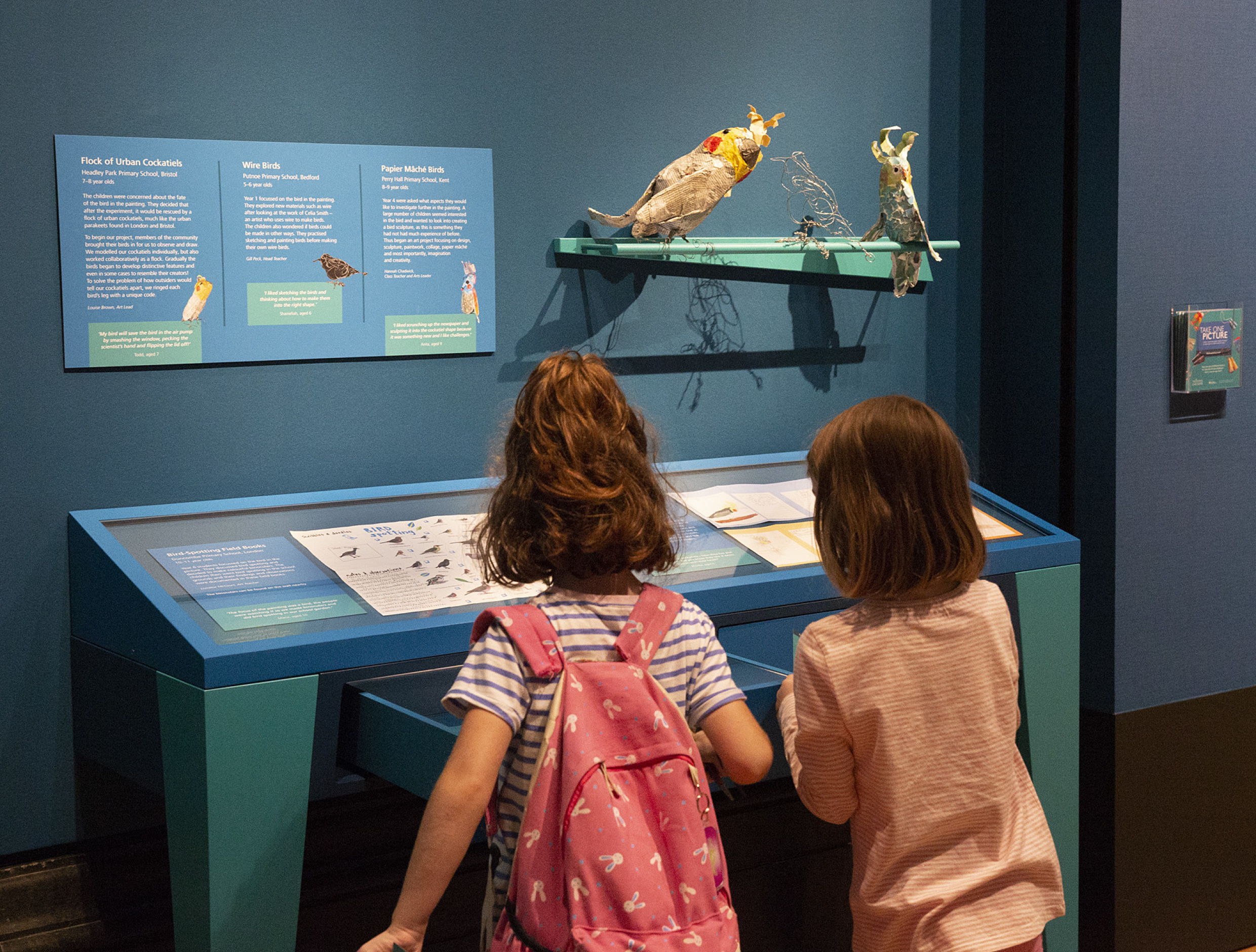 Two small children interacting with exhibition display on birds