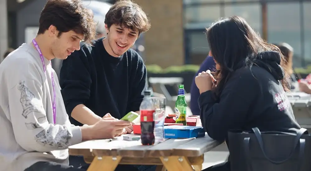 Students sitting on benches outside EleHouse