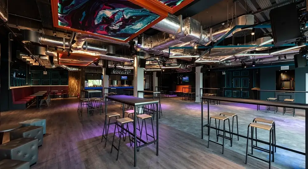 A open plan room with three high tables and chairs around each table