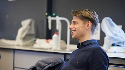 Student sitting in a chair leaning back smiling
