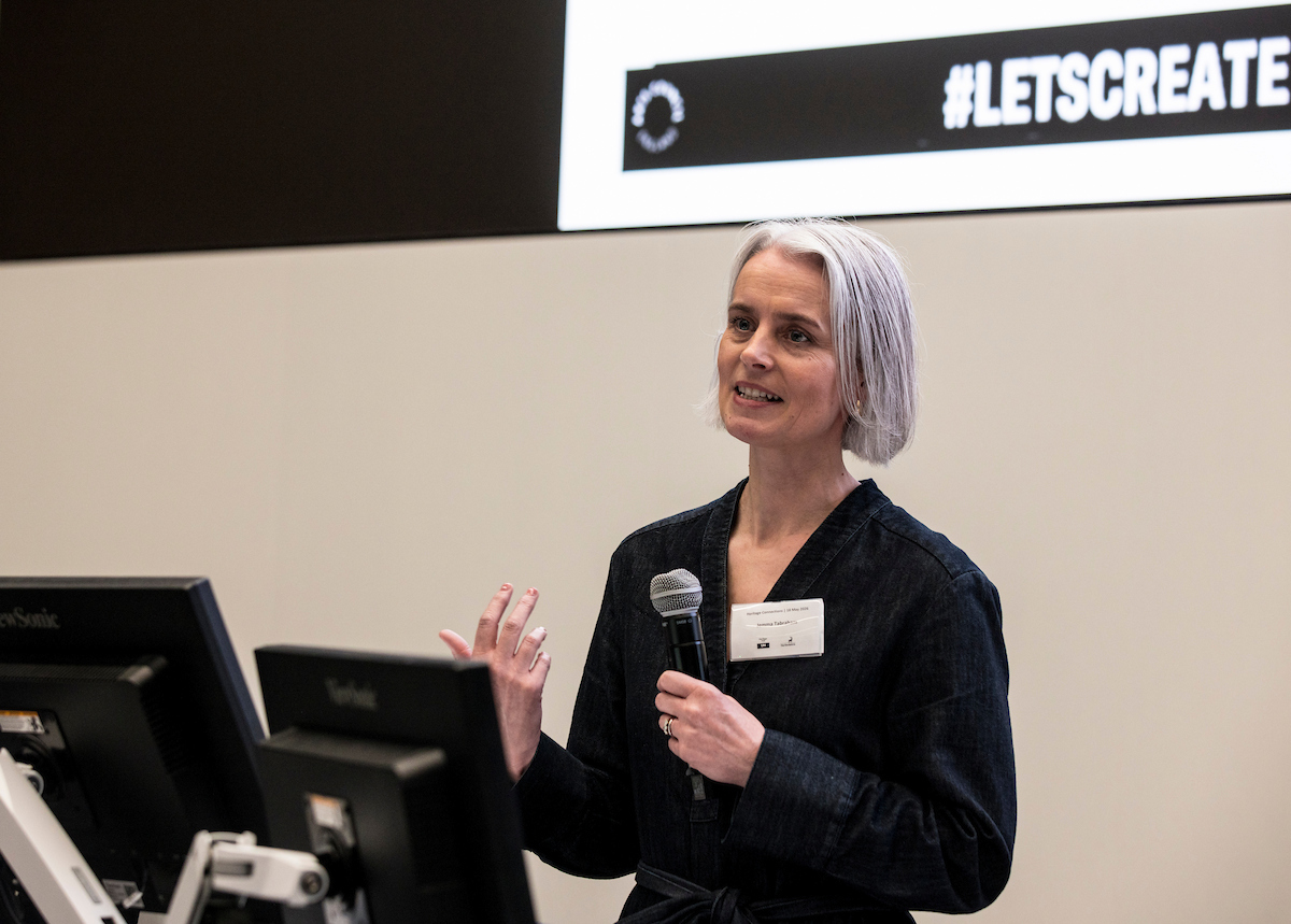 White woman with grey hair presenting on stage