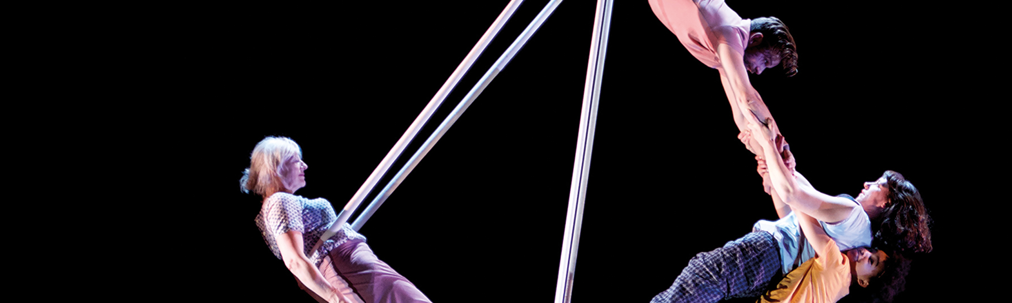 Ockham's Razor performers swinging from trapeze behind black background 