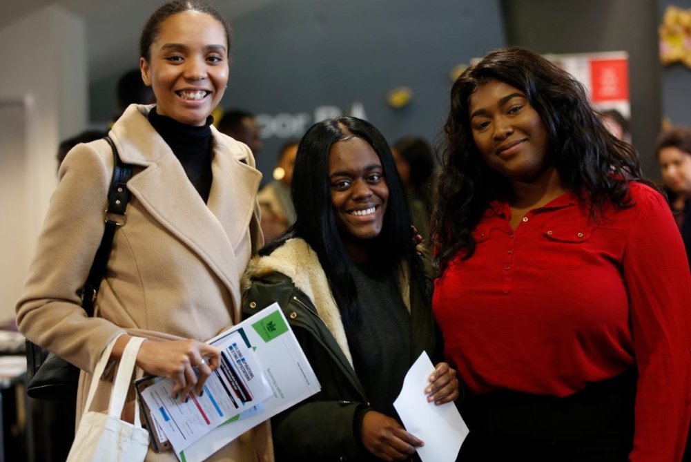Three BAME students smiling at event