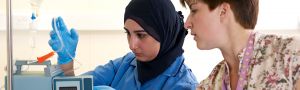 a staff member helps a student set up a machine