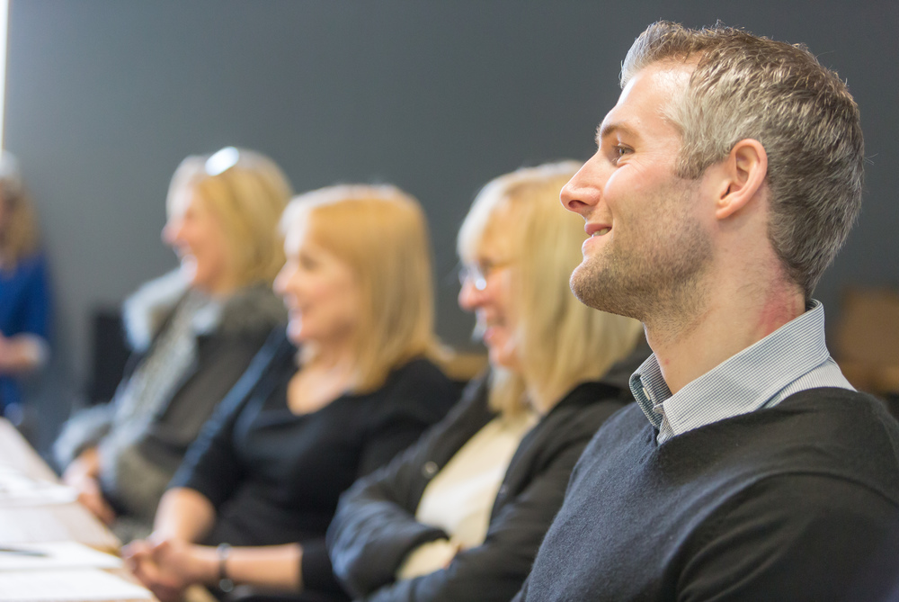 Man sitting in meeting with women