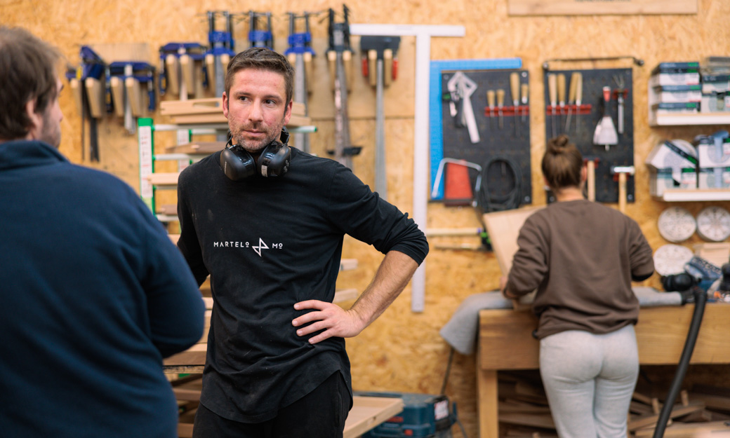 Lucas talking in the workshop with another staff member