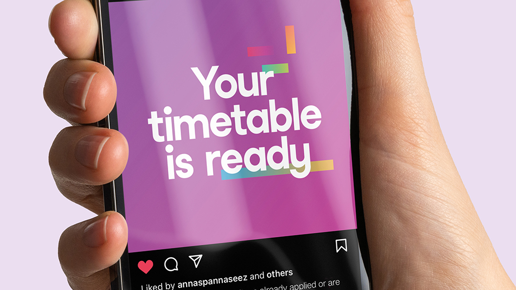 hand holding an iPhone, displaying a social media post by the university of hertfordshire