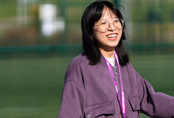 smiling student standing in a field