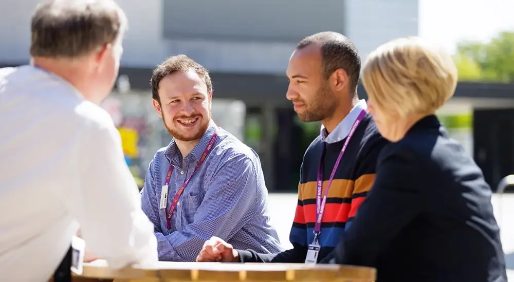 Students sitting on benches outside EleHouse